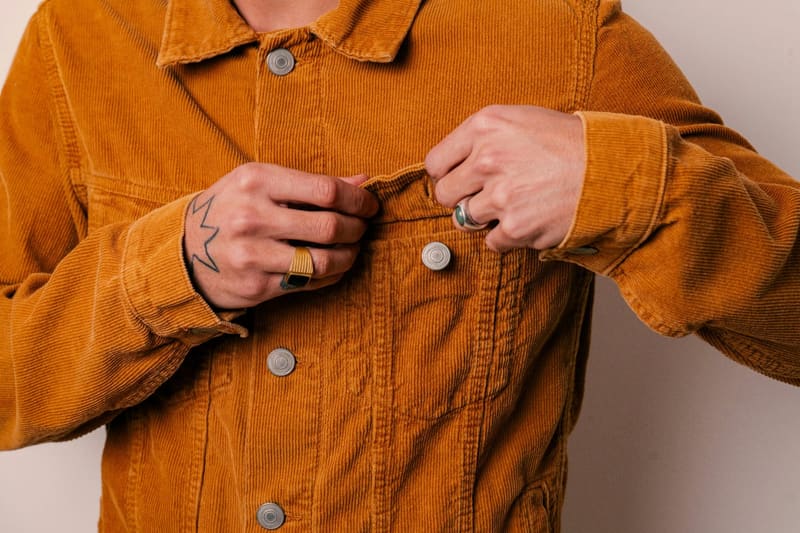 hands buttoning a corduroy jacket