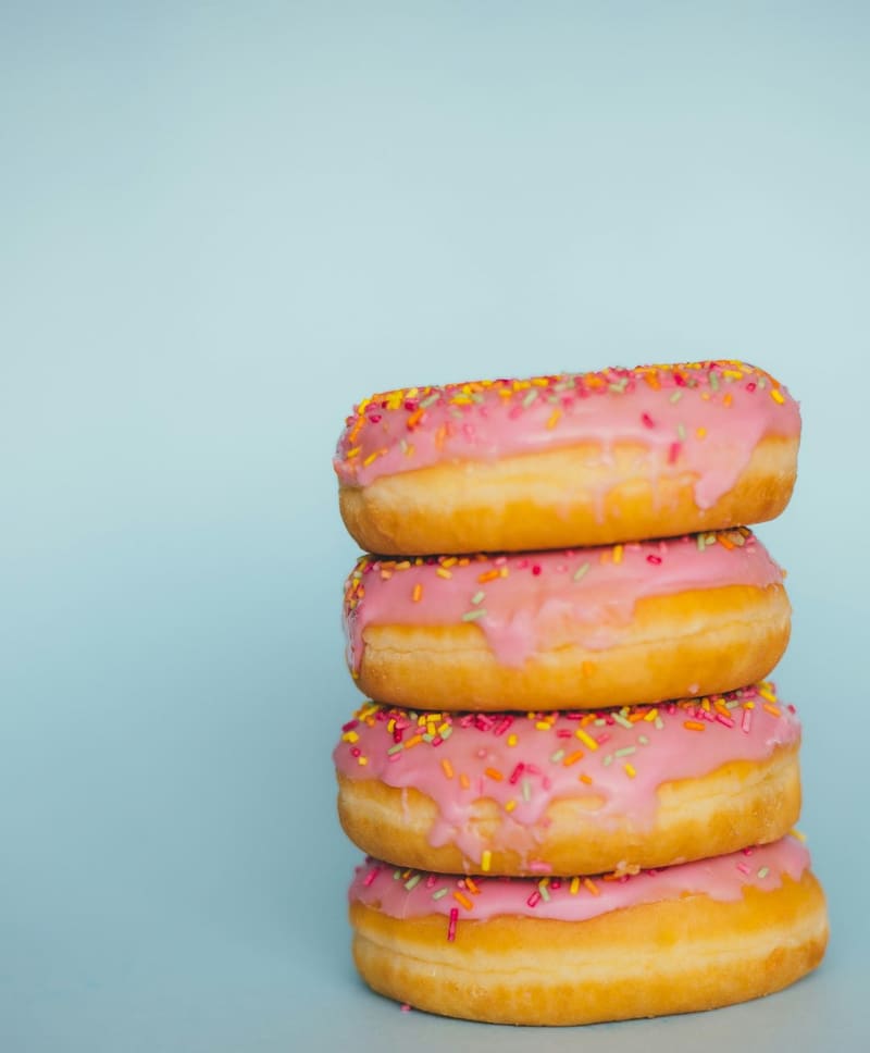 a stack of pink iced doughnuts