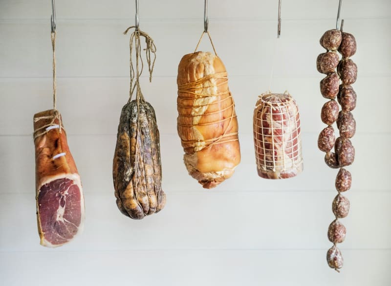 cured meats hanging on hooks