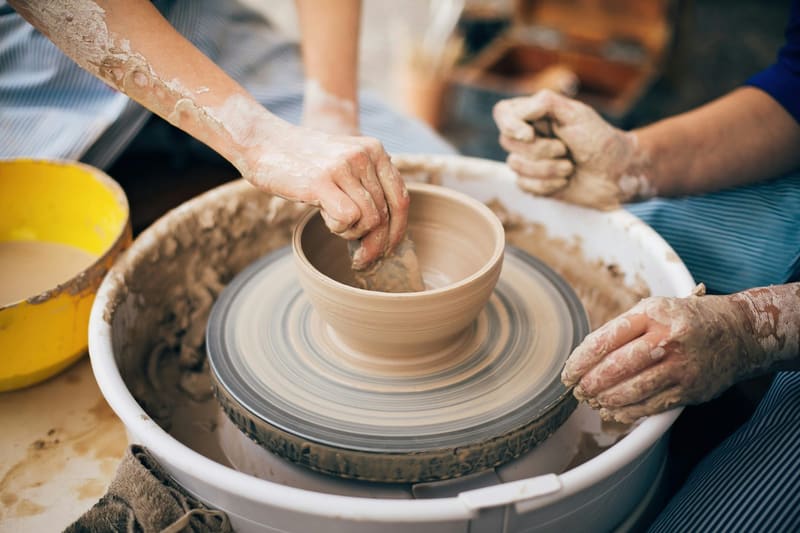 a bowl being thrown on a wheel