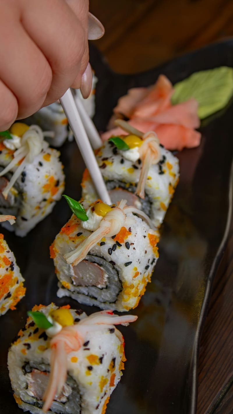 picking up a sushi roll with chopsticks
