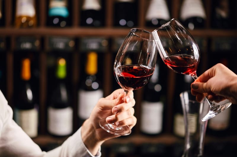 two red wine glasses clinked in a cellar