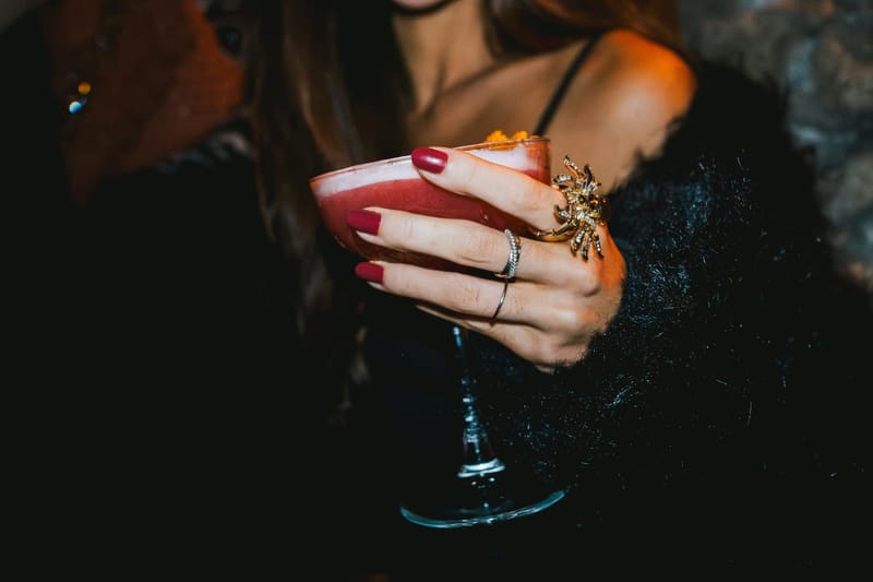 a cocktail held in a ringed hand