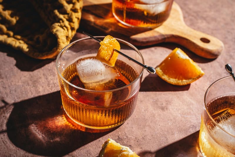 an amber cocktail with orange peel