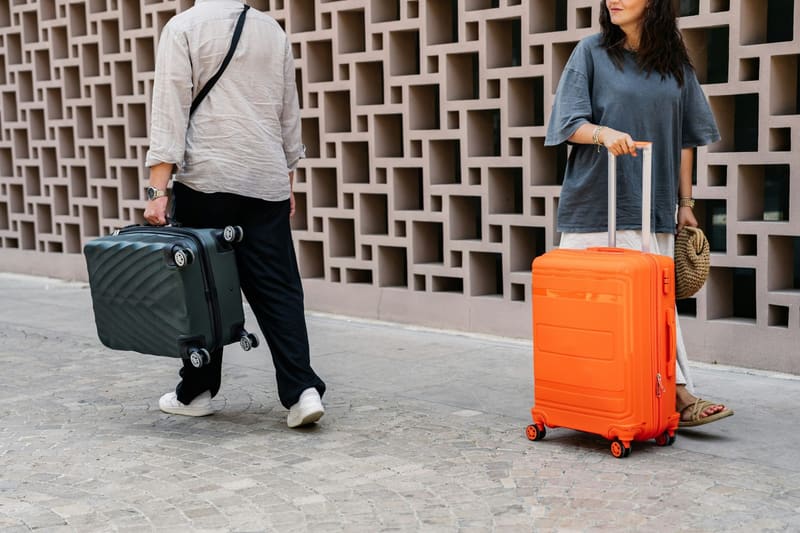 two travellers wheeling suitcases