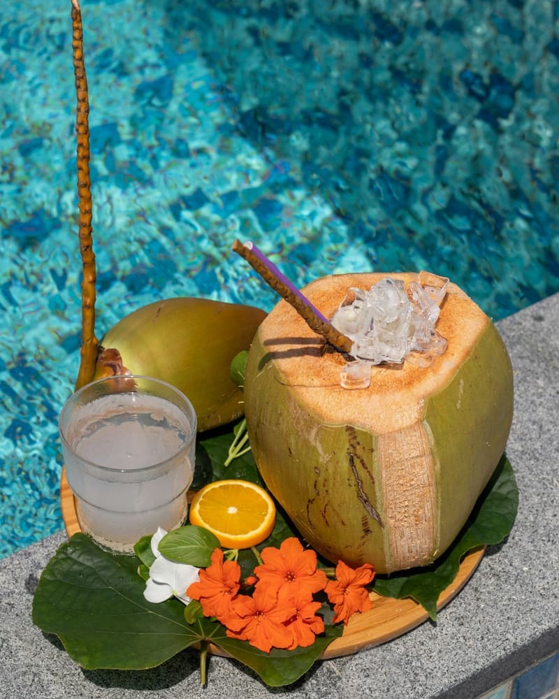 a coconut drink beside a pool