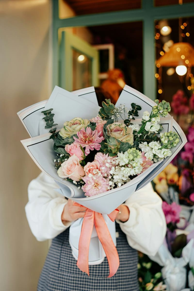 hands holding a wrapped bouquet