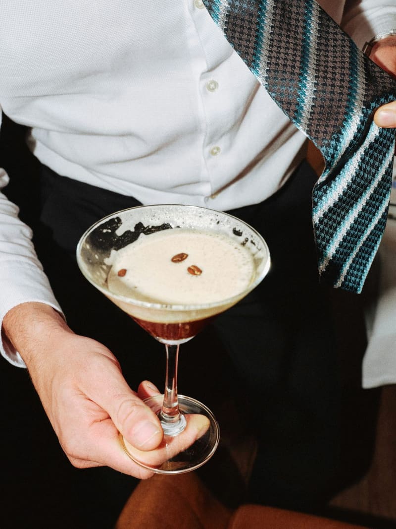 a hand holding an espresso martini