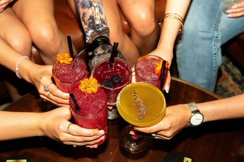 four cocktails held over a table