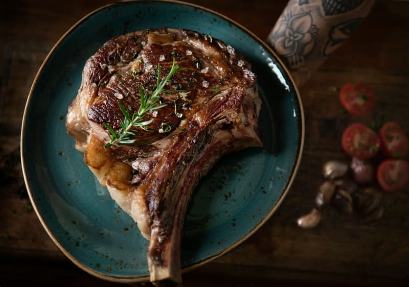 a grilled bone in steak on a plate
