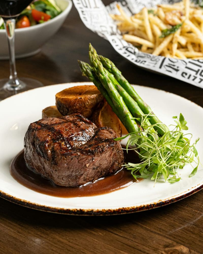 a fillet steak with asparagus and chips
