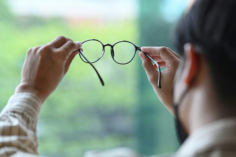 hands holding a pair of spectacles