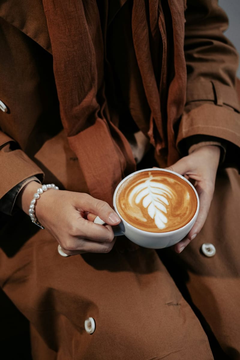 hands holding a latte with rosetta art