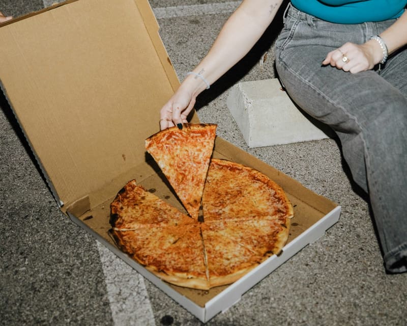 an open pizza box on the ground