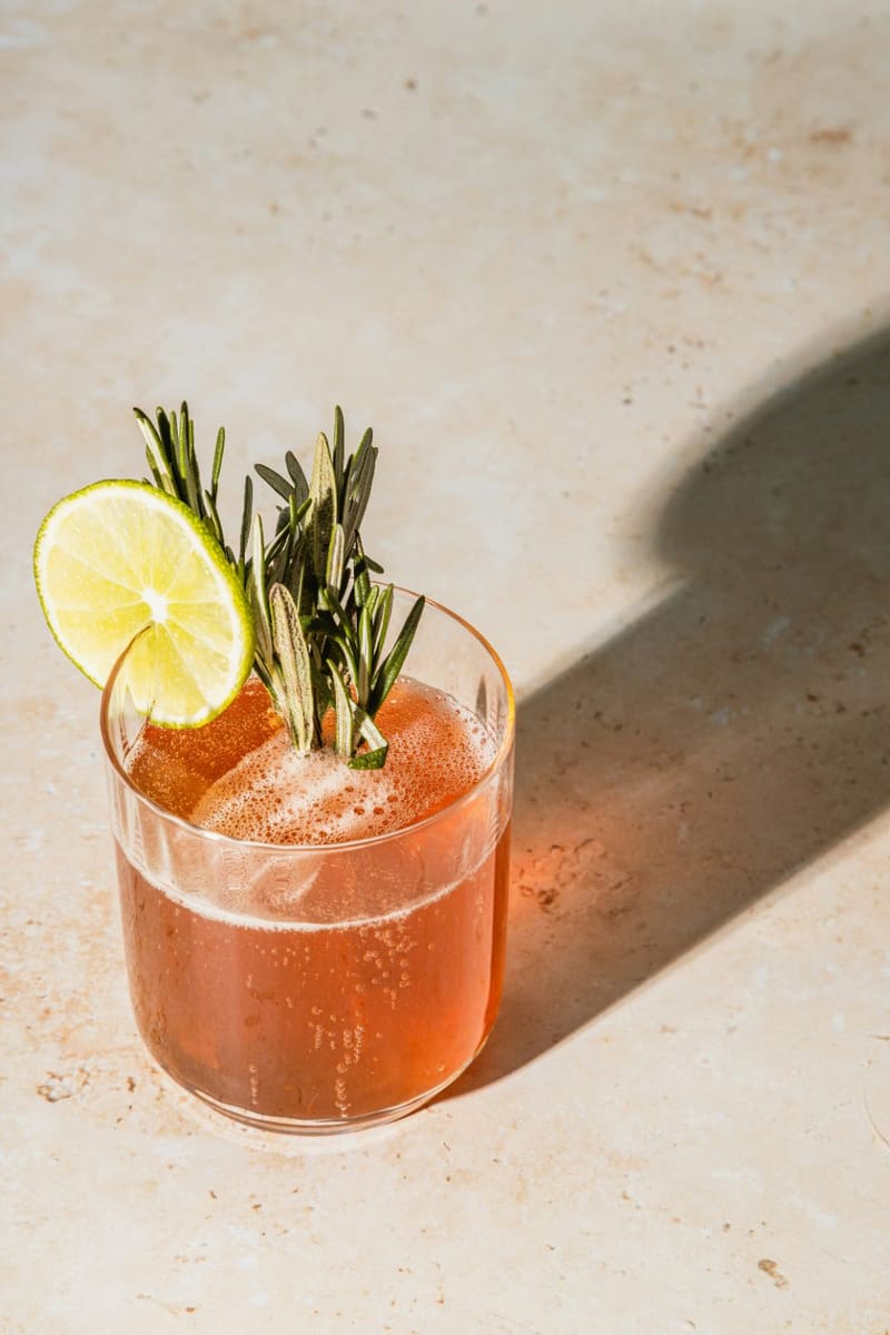 a cocktail with lime and rosemary