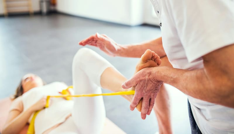 a physiotherapist stretching a foot