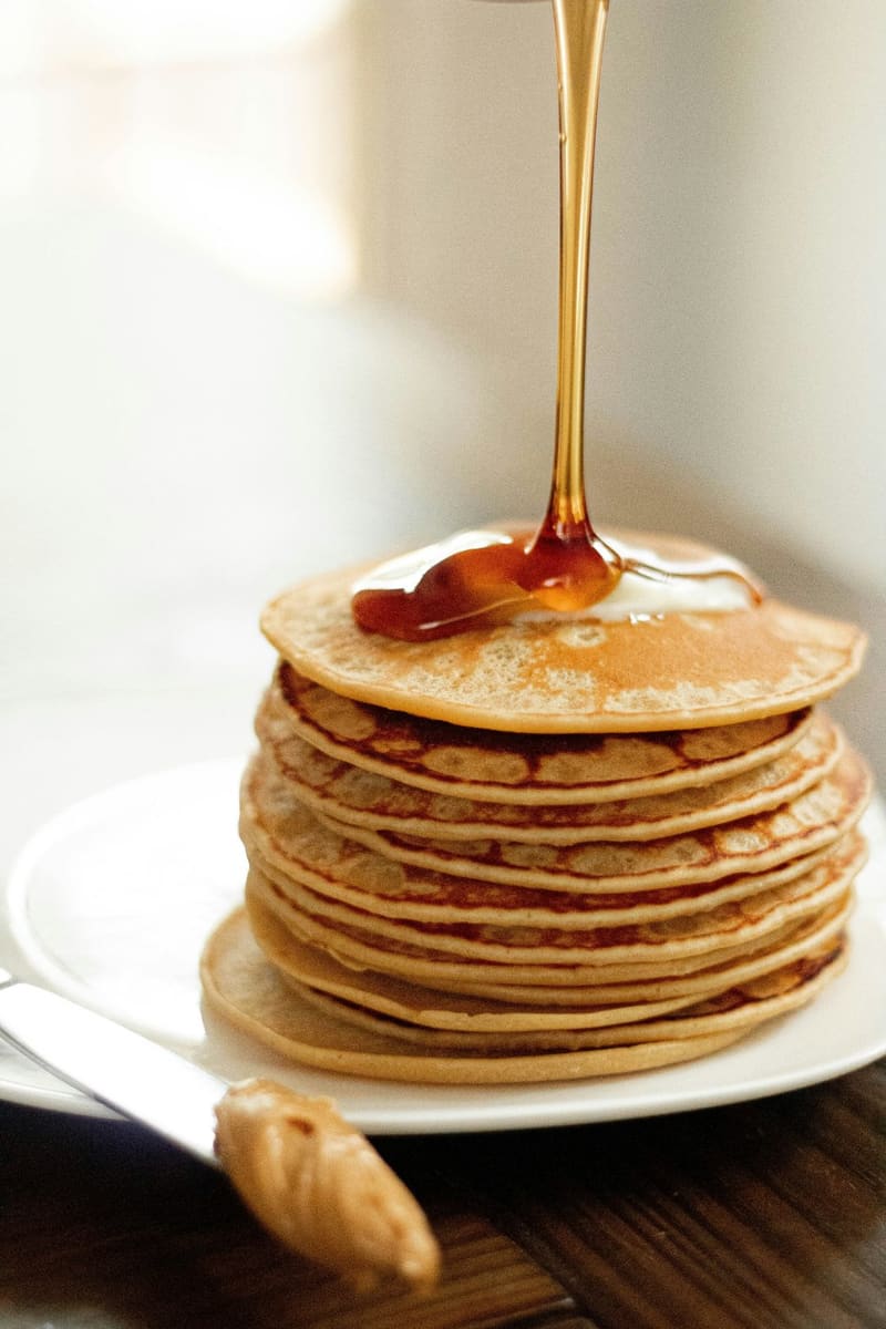 syrup poured over a stack of pancakes