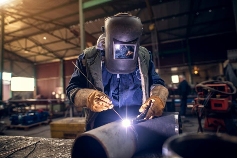 a welder working on a steel pipe