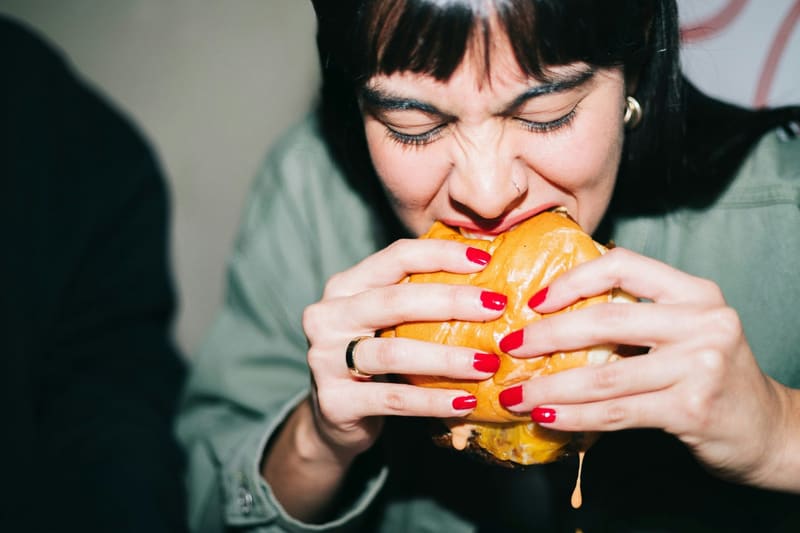 a woman biting into a burger