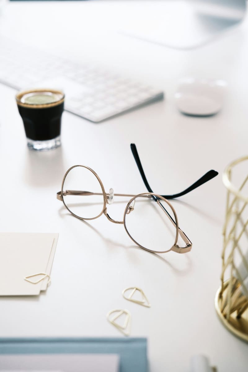 spectacles and coffee on a white desk