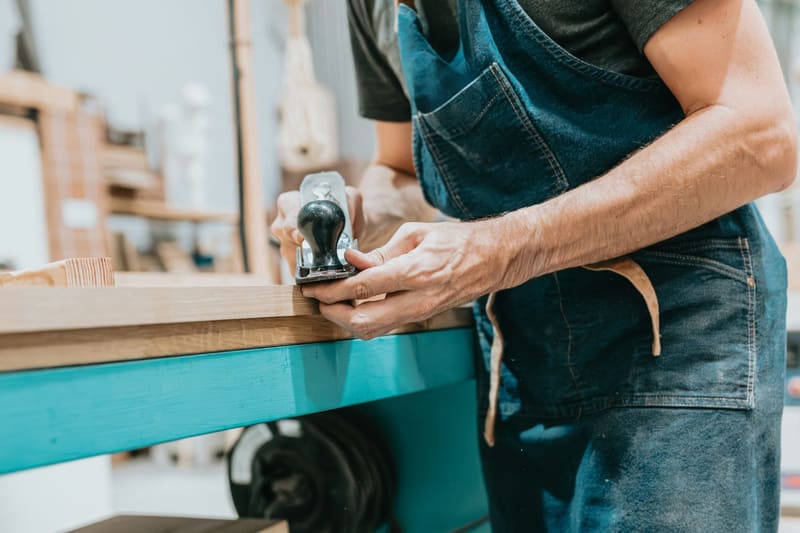 hands stamping a wooden board