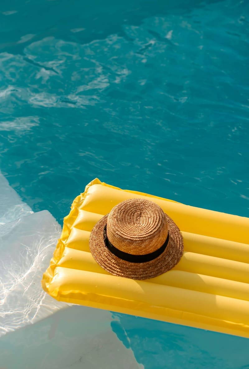 a straw hat on a yellow lilo