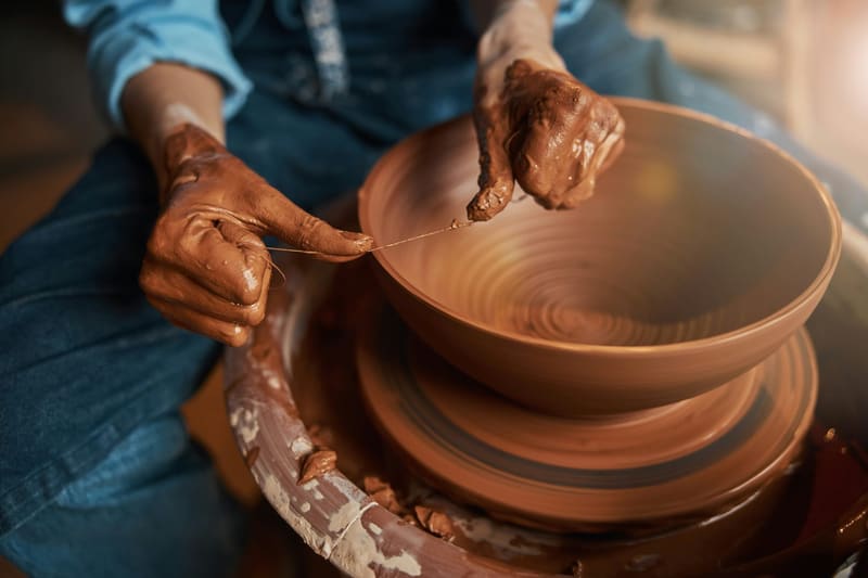 hands finishing a terracotta bowl