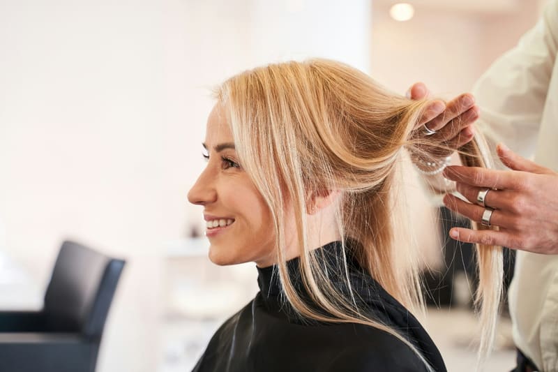 a blonde woman having her hair styled