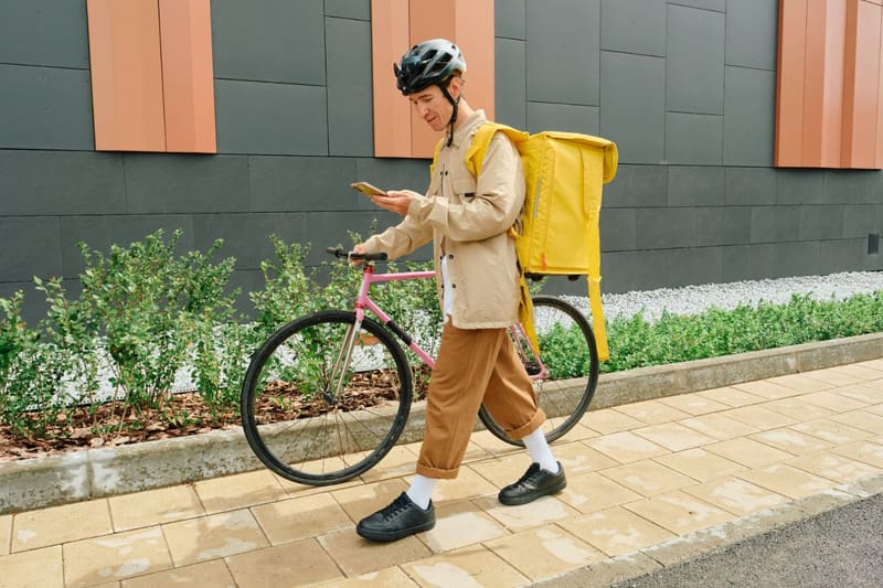 a courier with a bike and a food bag
