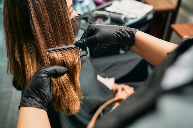 a colourist combing long hair