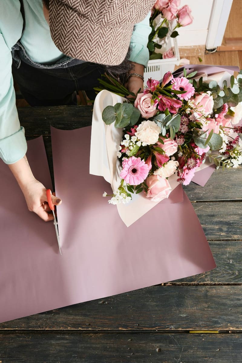 hands wrapping a bouquet in paper