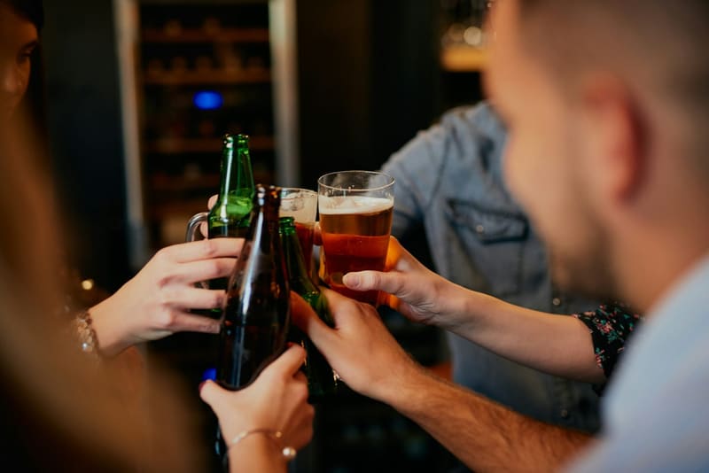 beer bottles and a glass clinked