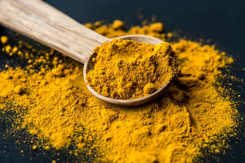 turmeric powder on a wooden spoon