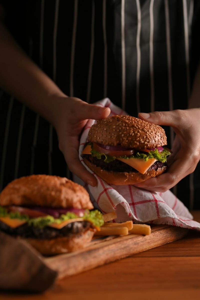 hands holding a cheeseburger