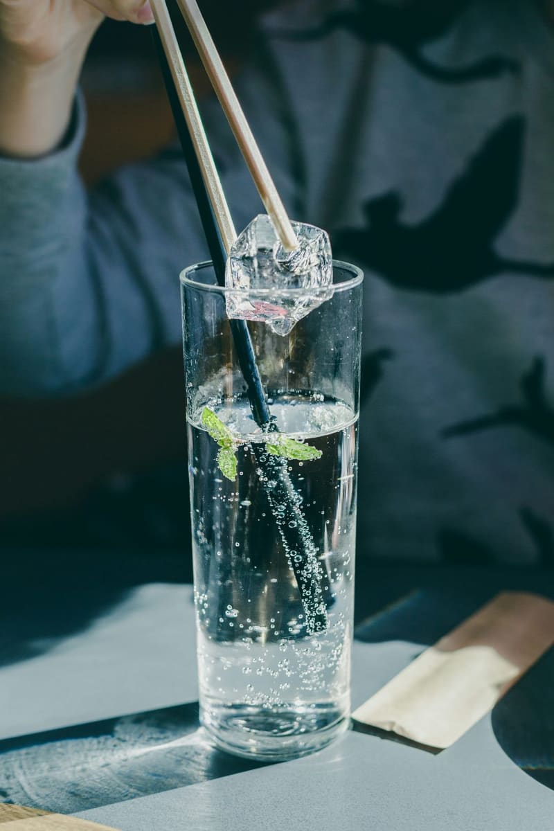 a tall glass of soda with mint