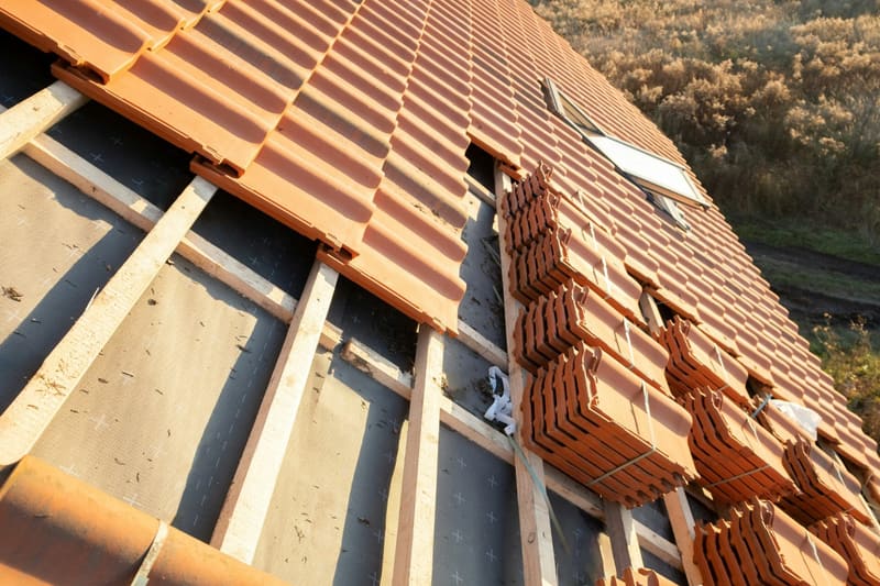 a tiled roof half laid on battens