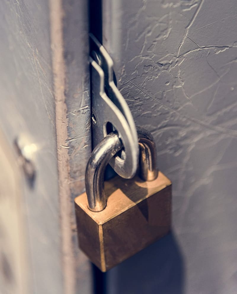 a brass padlock on a hasp